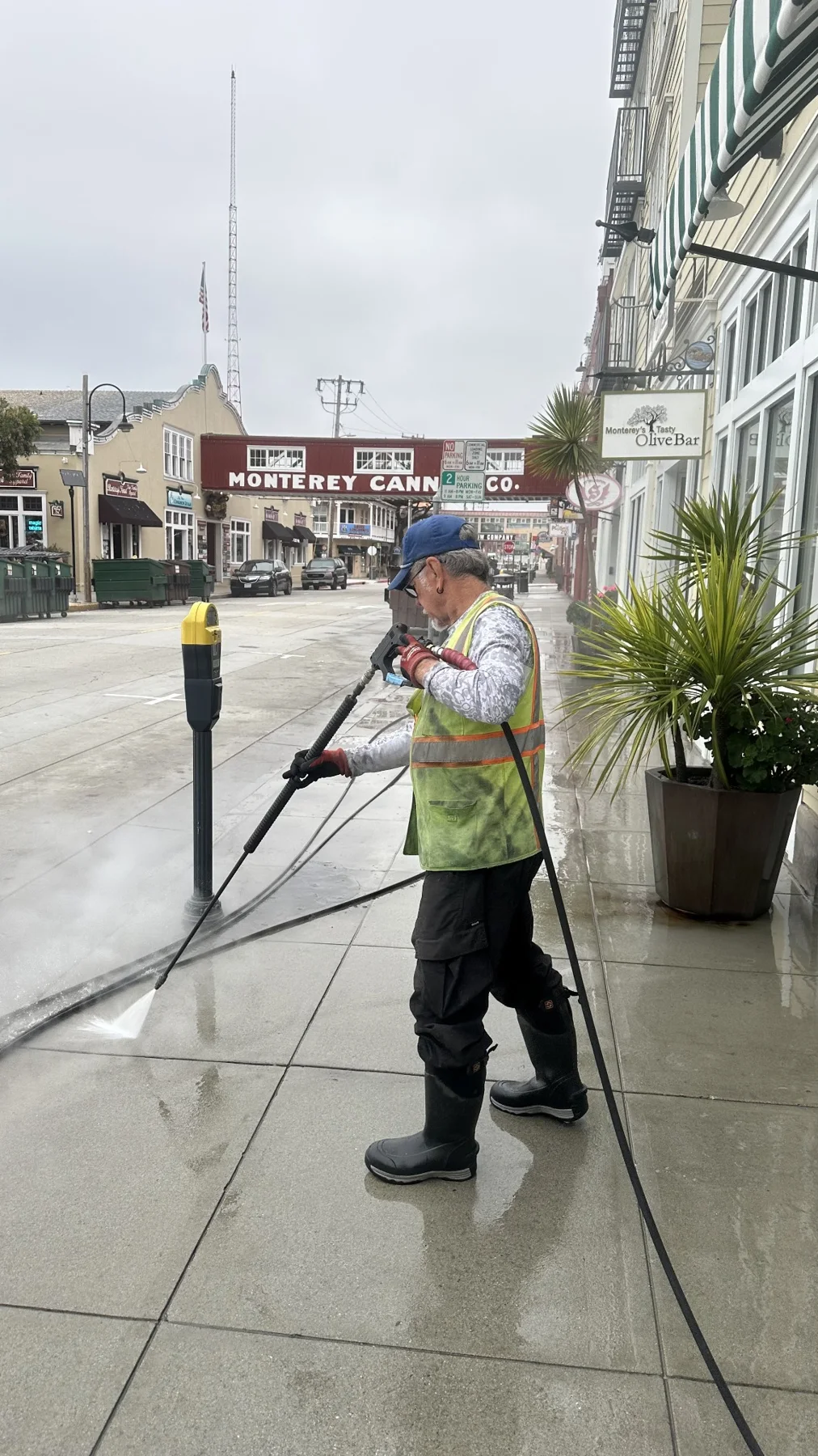 Team member pressure washing a sidewalk